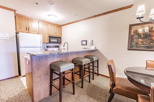 kitchen with stove, light brown cabinetry, crown molding, white refrigerator, and stone countertops