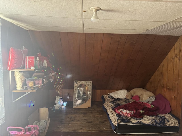 bedroom with dark hardwood / wood-style floors and wood walls