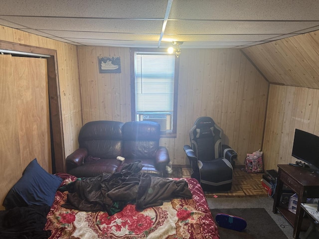 bedroom with cooling unit, wood walls, and vaulted ceiling