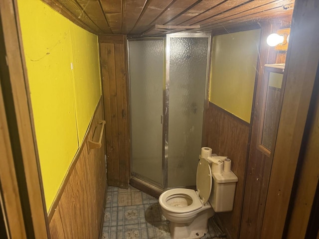 bathroom featuring toilet, wooden ceiling, and wood walls