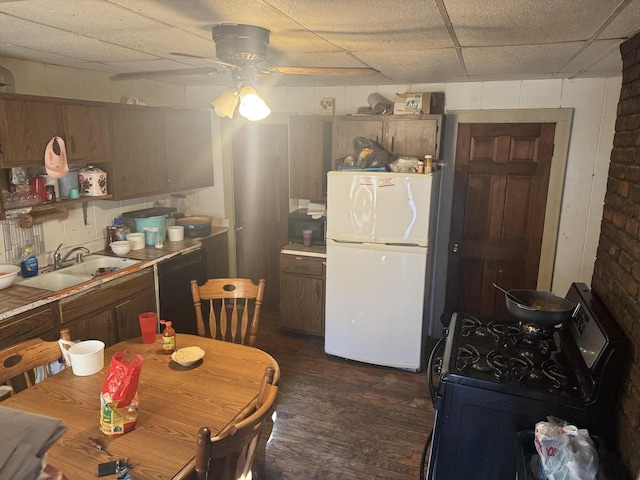 kitchen with black appliances, a paneled ceiling, ceiling fan, and sink