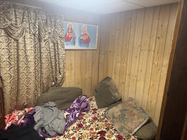 bedroom featuring carpet and wooden walls