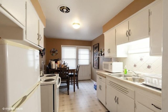 kitchen with tasteful backsplash, sink, white cabinets, and white appliances