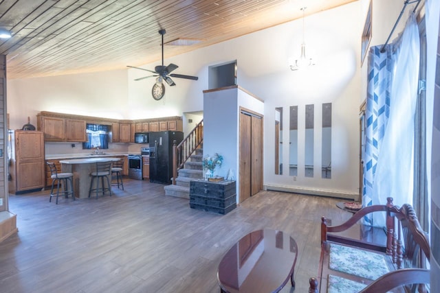 living room with wood ceiling, ceiling fan, baseboard heating, wood-type flooring, and high vaulted ceiling