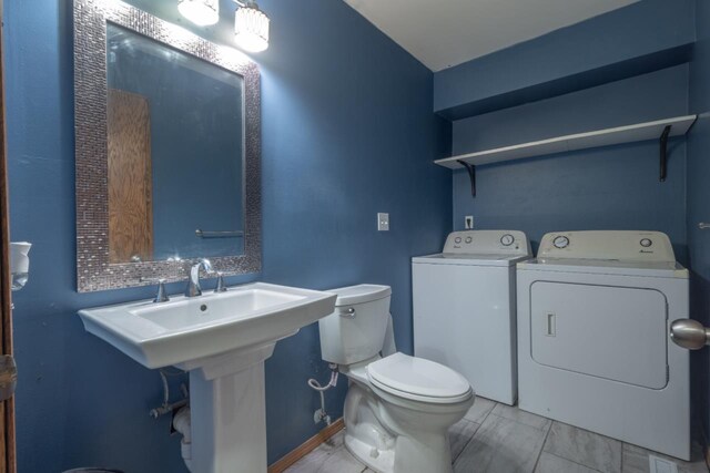 bathroom featuring tile patterned floors, washer and clothes dryer, and toilet