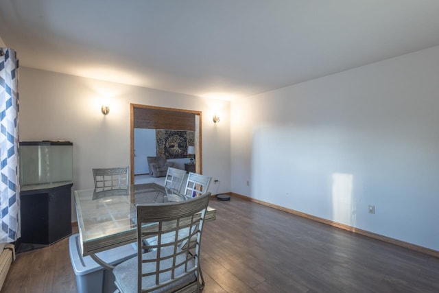 dining space featuring dark hardwood / wood-style flooring and a baseboard heating unit