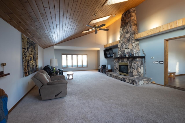 living room featuring a skylight, wood ceiling, ceiling fan, high vaulted ceiling, and a stone fireplace