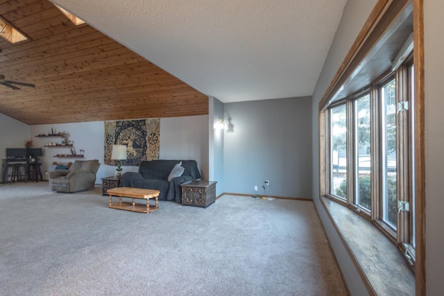 carpeted living room with wooden ceiling and vaulted ceiling with skylight