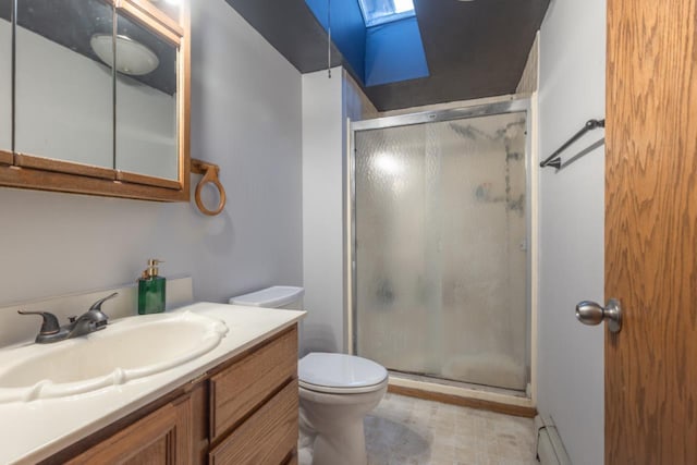 bathroom featuring a skylight, vanity, baseboard heating, toilet, and a shower with shower door