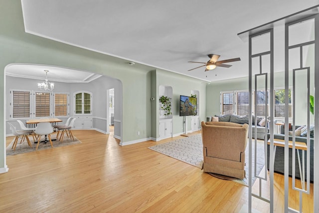 living room featuring light hardwood / wood-style flooring, ceiling fan with notable chandelier, and ornamental molding