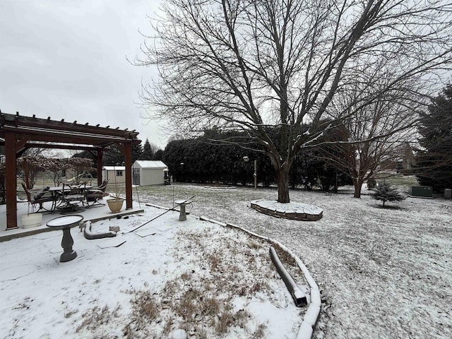 snowy yard with a pergola and a shed