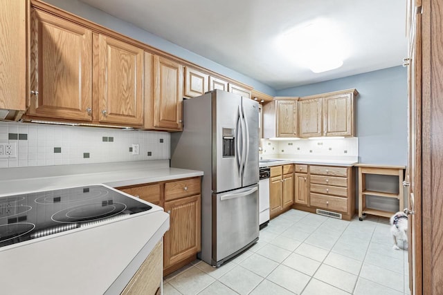 kitchen featuring dishwasher, range, stainless steel fridge, and backsplash