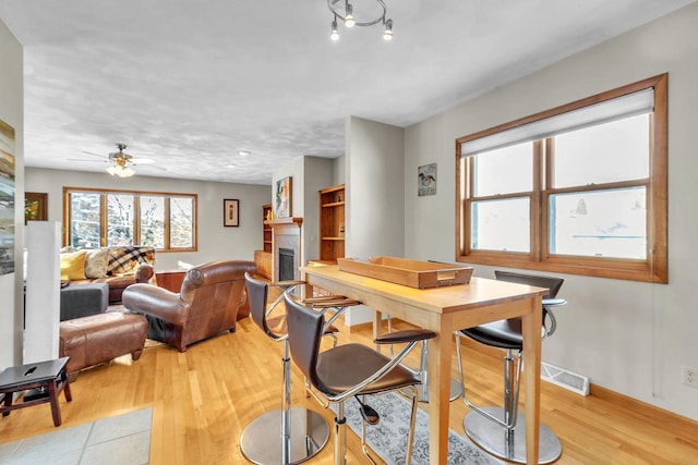 dining space with ceiling fan and light hardwood / wood-style flooring