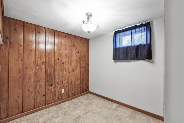 unfurnished room featuring wooden walls