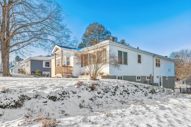 view of snow covered back of property