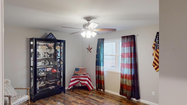 sitting room featuring ceiling fan and dark wood-type flooring