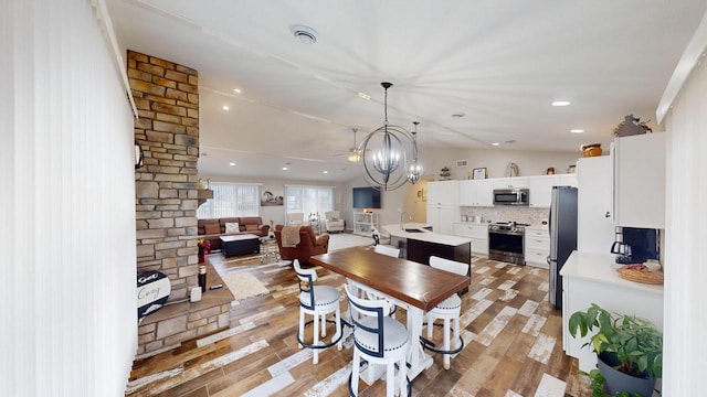 dining area with hardwood / wood-style flooring, a notable chandelier, and sink