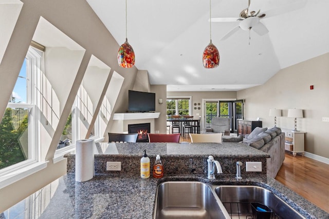 kitchen with a healthy amount of sunlight, sink, lofted ceiling, and hanging light fixtures