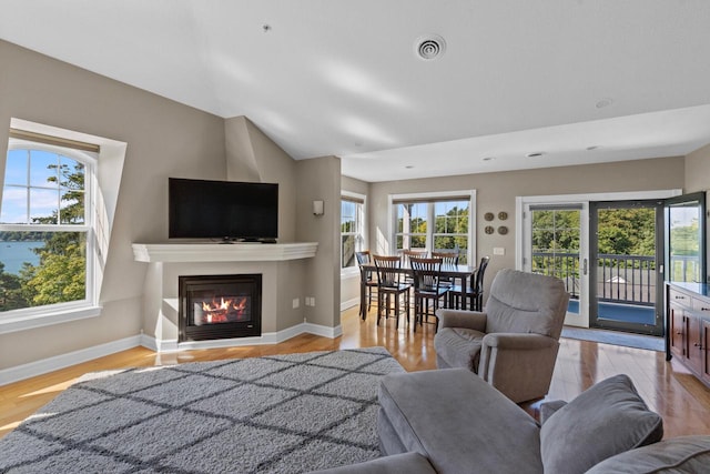 living room with a wealth of natural light and light hardwood / wood-style flooring