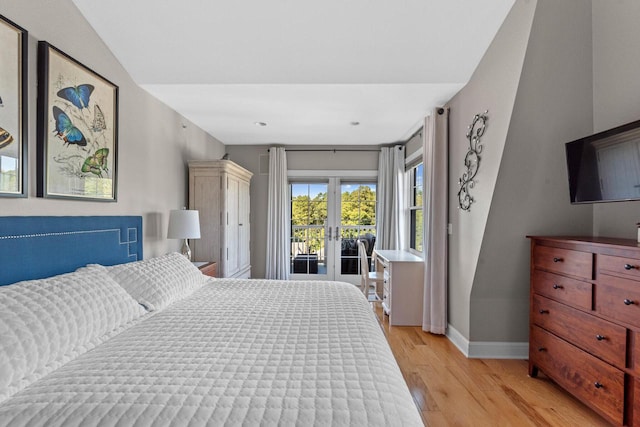 bedroom with french doors, access to outside, and light hardwood / wood-style flooring