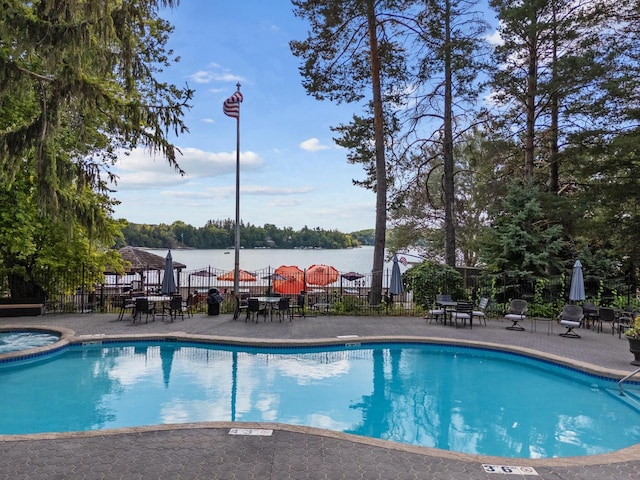 view of swimming pool with a community hot tub and a water view