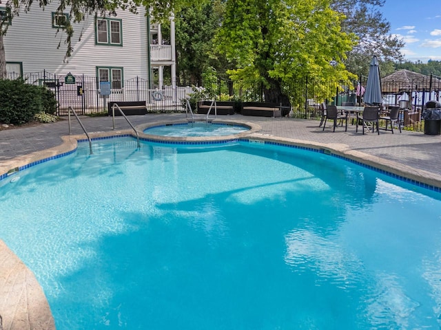 view of pool with a patio area and a community hot tub