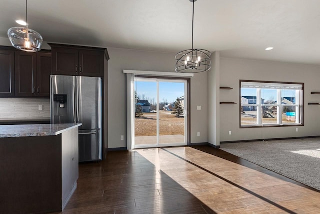 kitchen with stainless steel fridge, dark brown cabinets, a chandelier, dark hardwood / wood-style floors, and hanging light fixtures