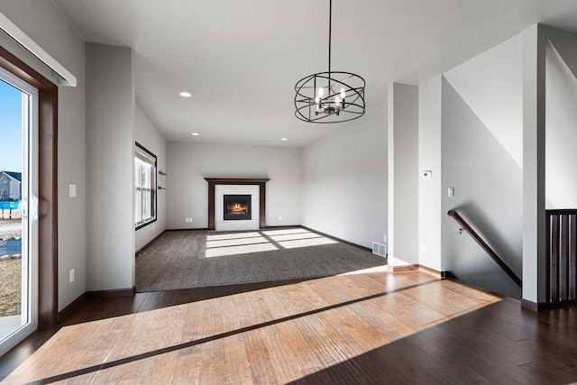 unfurnished living room with dark hardwood / wood-style floors and an inviting chandelier