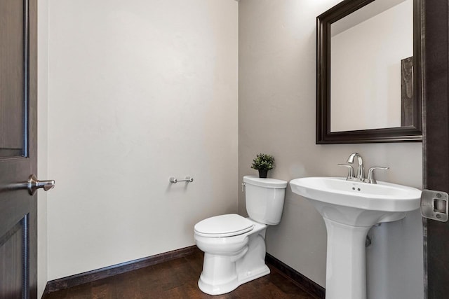 bathroom featuring sink, hardwood / wood-style floors, and toilet