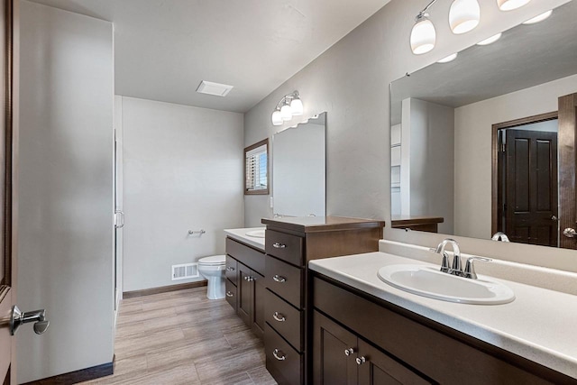 bathroom featuring vanity, hardwood / wood-style flooring, and toilet