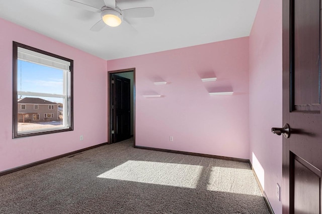 unfurnished room with ceiling fan and carpet