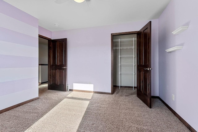 unfurnished bedroom with carpet floors, a closet, and ceiling fan