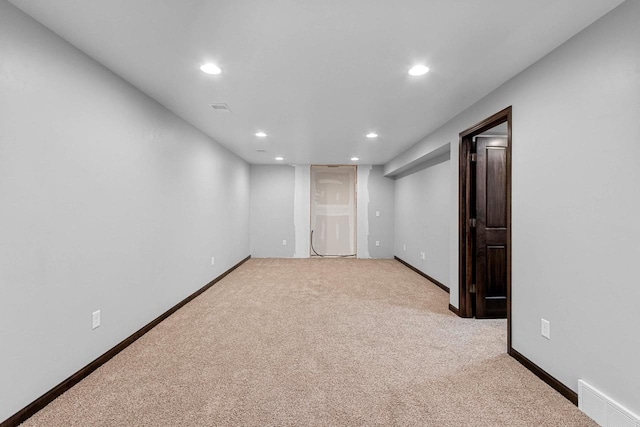 spare room featuring light carpet