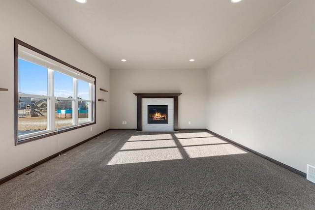 unfurnished living room with dark colored carpet