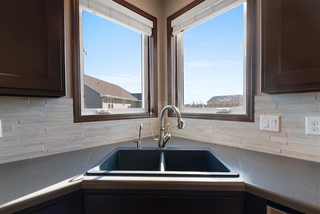 kitchen with tasteful backsplash, sink, and dark brown cabinets