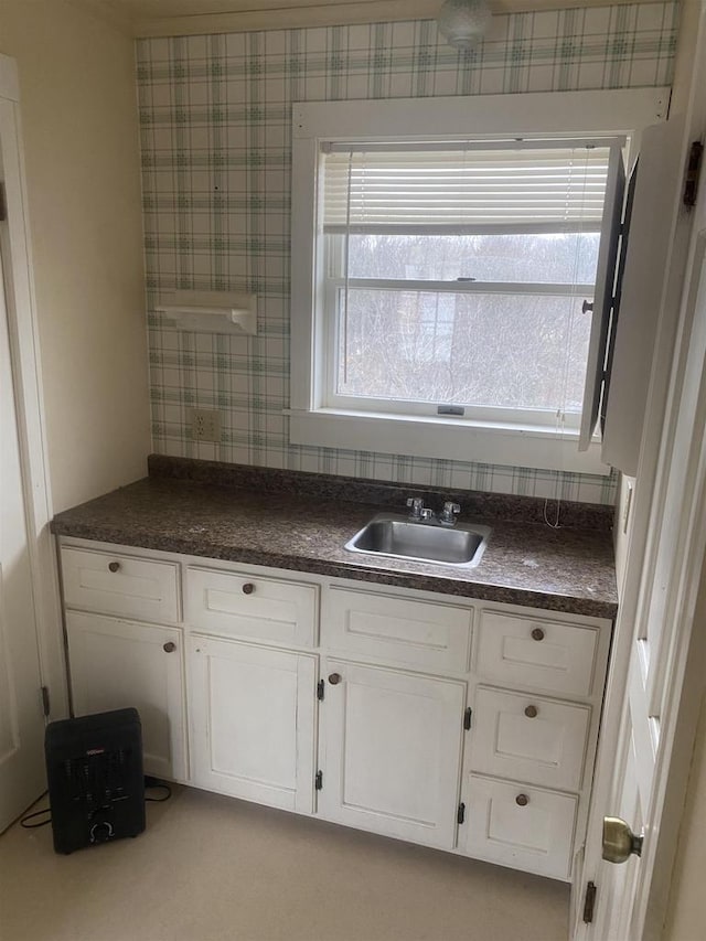 kitchen featuring white cabinetry and sink