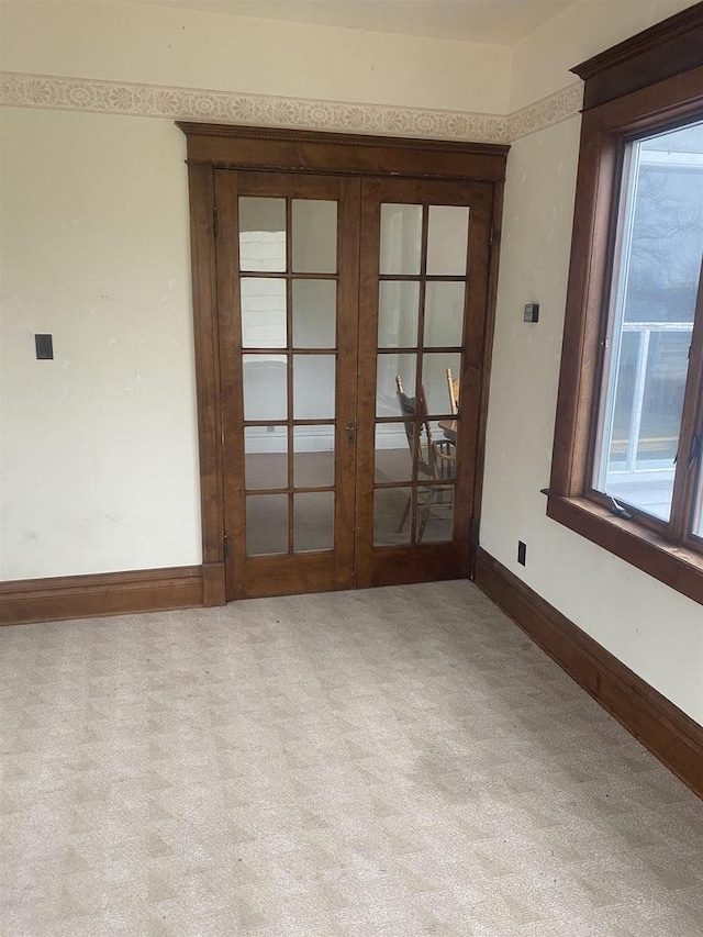 spare room with light carpet and french doors