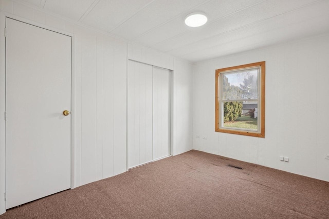 unfurnished bedroom with carpet floors and a closet