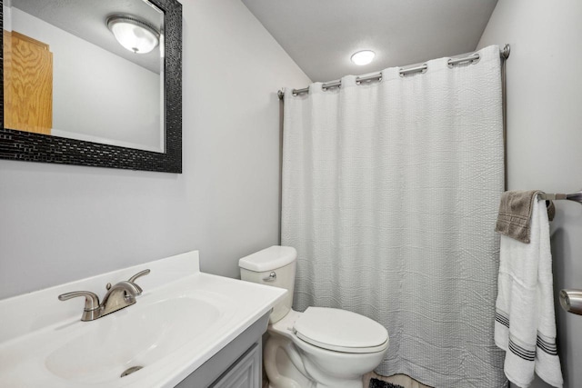 bathroom featuring a shower with shower curtain, vanity, and toilet