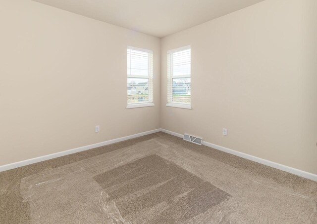 6407 Prairie Wood Dr, Mcfarland, WI 53558 - spare room featuring carpet floors, visible vents, and baseboards
