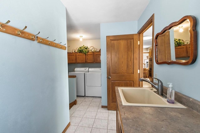 laundry area with light tile patterned flooring, cabinets, separate washer and dryer, and sink