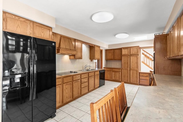 kitchen featuring sink, light tile patterned floors, custom range hood, decorative backsplash, and black appliances