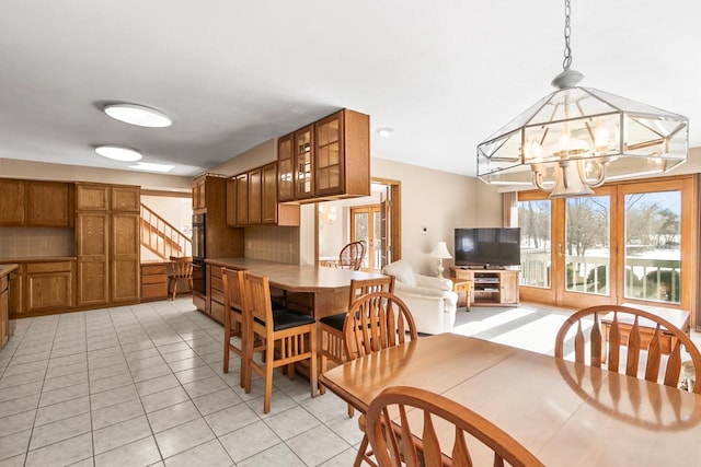 tiled dining area featuring a chandelier