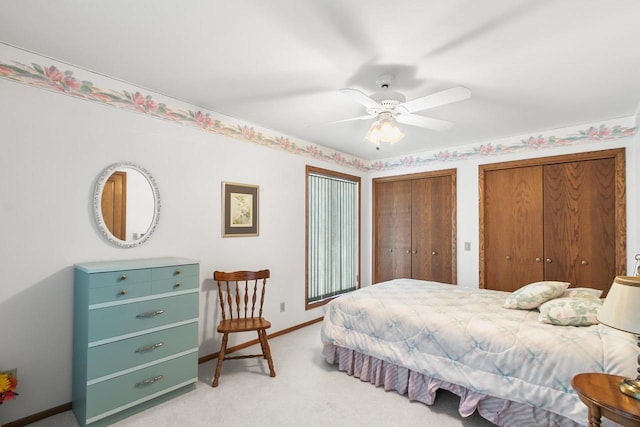 carpeted bedroom featuring two closets and ceiling fan