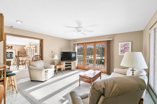 tiled living room featuring ceiling fan with notable chandelier