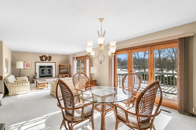 dining space with a chandelier and light carpet