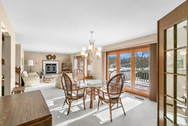 dining space featuring light carpet and a notable chandelier