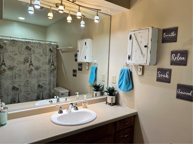 bathroom featuring a shower with curtain, vanity, and toilet