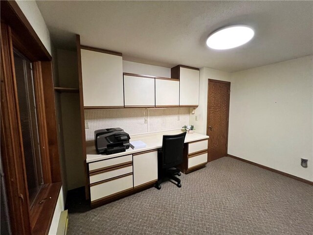 home office featuring built in desk and light carpet