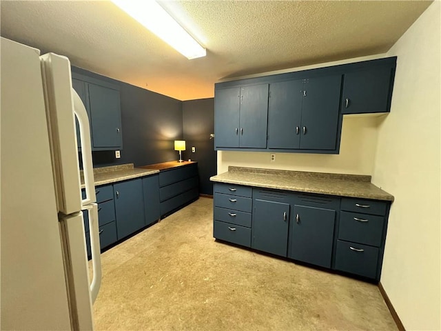 kitchen with white fridge and a textured ceiling